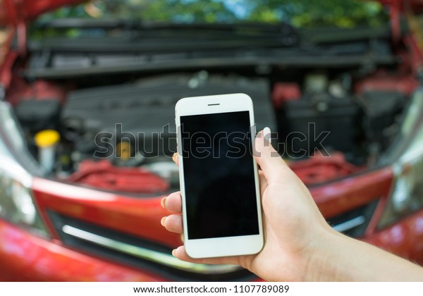 Using a mobile phone call a car mechanic because\
car was broken.