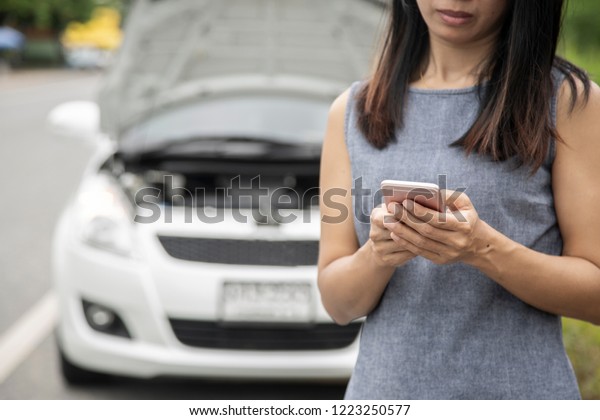 Using a mobile phone call a car mechanic because\
car broken.