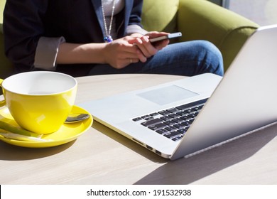 Using mobile phone and laptop computer in cafe