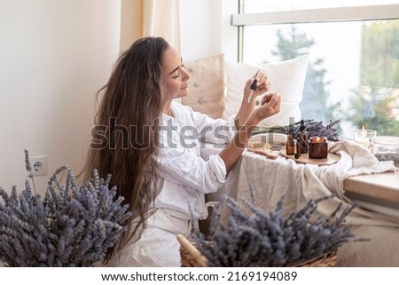 Using natural essential oil in a home spa ritual. A woman takes care of her skin and hair. Foto d'archivio © 