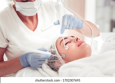 Using new equipment. Close up of professional beauty expert using new equipment for deep facial cleansing