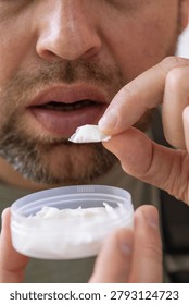 using nicotine pouch background plastic box surface close up of bearded man taking white snus portion swedish tobacco free alternative smokeless product concept of addiction, bad habits, nicotine