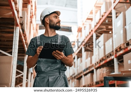 Using notepad. Foreman is in the storehouse, shipping distribution business.