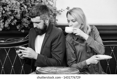 using phone while date. Morning coffee. woman and man with beard relax in cafe. Couple in love on romantic date. Brutal bearded hipster and girl drink coffee. First meet of girl and mature man.