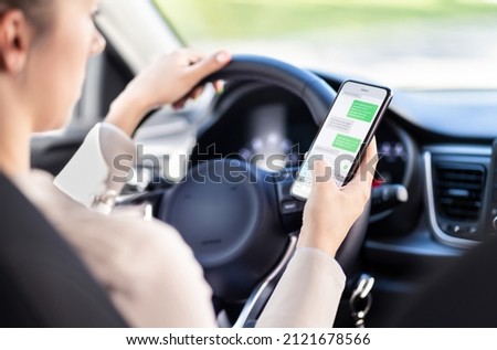 Using phone while driving car. Distracted driver texting while in vehicle. Irresponsible woman checking sms message with mobile cellphone in traffic. Holding smartphone in hand. Auto accident concept.
