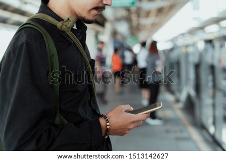Using a phone while waiting for skytrain.