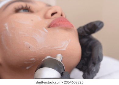 Using an RF electromagnetic device for radiofrequency skin tightening or double chin reduction. At a facial care, dermatologist or aesthetic clinic.