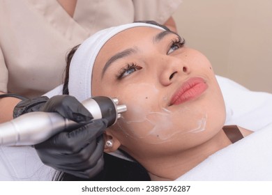 Using an RF electromagnetic device for radiofrequency skin tightening or contouring treatment. At a facial care, dermatologist or aesthetic clinic.