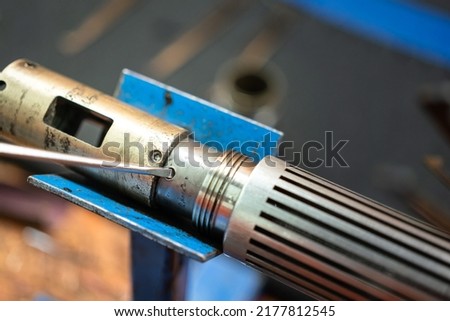 Using a screwdriver to reparing an electronic device. Industrial working action photo, close-up and selective focus.
