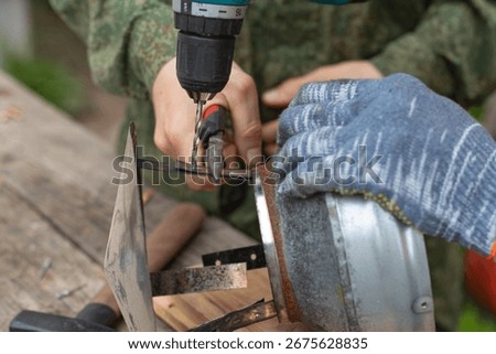 Using a screwdriver, the workers repair the chimney cap.