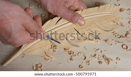 using a small gouge to add details on a feather carving