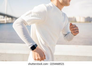 Using a smart fitness watch that measures the pulse and pressure on the arm. The trainer is a running sports man training in comfortable clothes. - Powered by Shutterstock