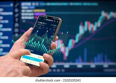 using smart phone in financial market, cryptocurrency market, - Shutterstock ID 2103103241