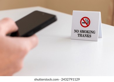 Using a smartphone at a non-smoking table - Powered by Shutterstock - Get 15% off with code: PIKWIZARD15
