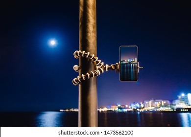 Using smartphone on flexible tripod to making the photo of sea night landscape - Powered by Shutterstock