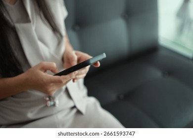 Using smartphone on sofa in house 