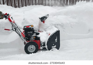 Using a snow blower to clear a path through deep snow during winter season