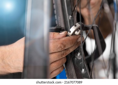 Using spoke wrench, an experienced bicycle master tightens the spokes on the wheel of bicycle transport. Adjustment of spokes on a mountain bike at home with a special screwdriver