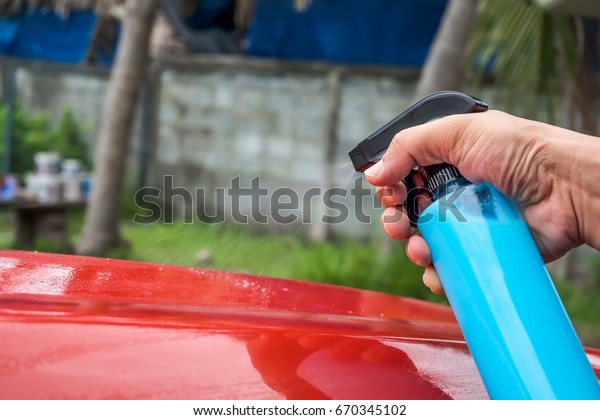 Using spray for wax the\
car surface.