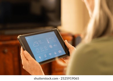 Using tablet for controlling smart home devices, woman managing home automation. Technology, connected devices, home security, wireless, digital, efficient