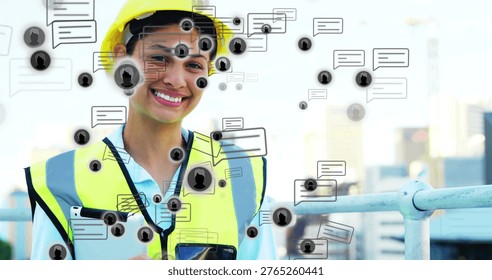 Using tablet, phone, engineer in yellow hardhat and hivis-vest with chat overlays on roof, copy space. Construction, urban, rooftop, safety, neon, collaboration, communication
