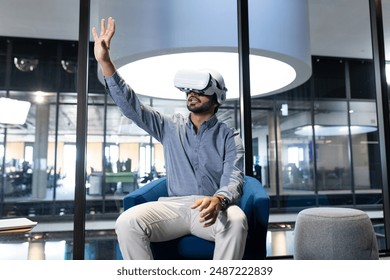 Using VR headset, man interacting with virtual environment in modern office. Technology, innovation, virtual reality, workplace, digital, futuristic