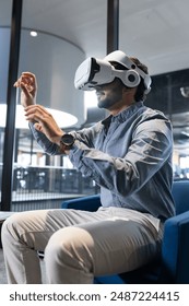 Using VR headset, man interacting with virtual environment in modern office. Virtual reality, technology, innovation, immersive, interactive, digital