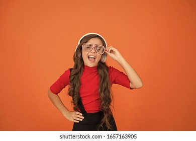 using wireless headset for DJ disco. small happy girl listen music in headphones. funny child in party glasses. time having fun. modern kid enjoy music. feeling stylish and confident. school radio dj.
