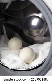 Using Wool Dryer Balls For More Soft Clothes While Tumble Drying In Washing Machine Concept. Discharge Static Electricity And Shorten Drying Time, Save Energy.