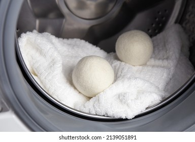 Using Wool Dryer Balls For More Soft Clothes While Tumble Drying In Washing Machine Concept. Discharge Static Electricity And Shorten Drying Time, Save Energy.