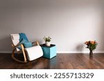 Using zoom technique to create wide angle shot of room interior with flowers and potted plant next to rocking chair. Can be used as a background for remote calls or conferences of virtual teams.
