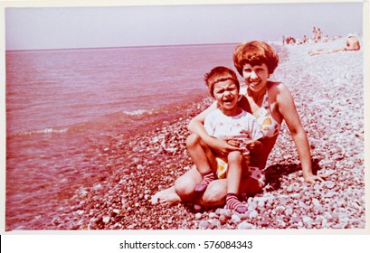 USSR, ABKHAZIA, LESELIDZE - CIRCA 1979: Vintage Family Photo Of Mother With Little Son On Black Sea Beach