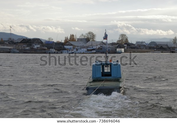 Ust-Barguzin Russia, tug boat pulling barge loaded\
with cars across\
river