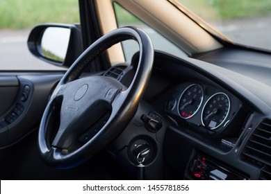 Usual Car Inside. Interior Details Of Well Maintained Vehicle. View On Steering Wheel. Ignition Key In The Lock In On Position. Dashboard Lights Indicate Service Icons. Backlight Turned On. 