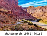 Utah Red Sandstones and Colorado River. The road runs along the shore of the Colorado River. The grandiose landscapes of America. Early morning on a fine autumn day. 