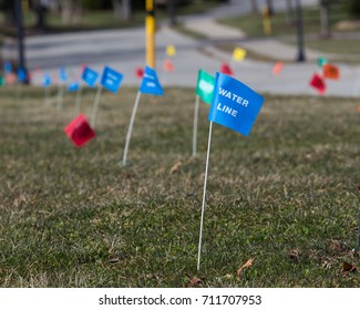 Utilities Location Flag Marking Underground Water, Electric, Telephone, Cable, Gas And Sewer Lines.