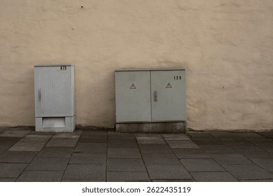 Utility boxes mounted on plastered exterior wall