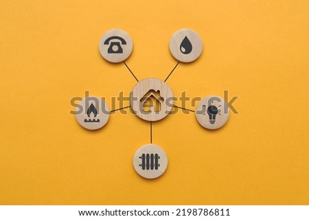 Utility icons on wooden mugs and a house nearby. A symbol of the necessary services in the house