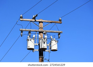 A utility pole with distribution transformers and power lines