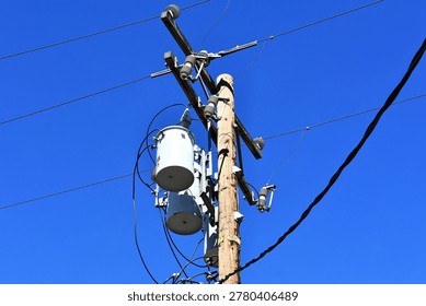A utility pole with distribution transformers and power lines
