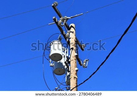 A utility pole with distribution transformers and power lines
