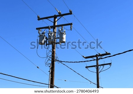 A utility pole with distribution transformers and power lines