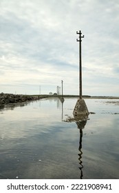 Utility Pole Near Shore Of Sea