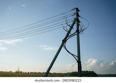 Utility pole standing tall, featuring insulators and numerous power lines extending across the open field, distributing electricity and essential services to remote areas