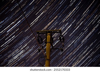 Utility pole with star trails behind - Powered by Shutterstock