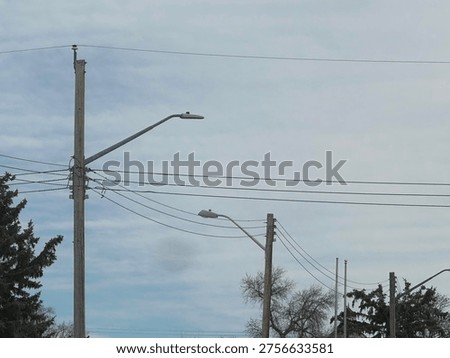 Utility power pole with overhead electrical lines against blue sky with cloud patterns