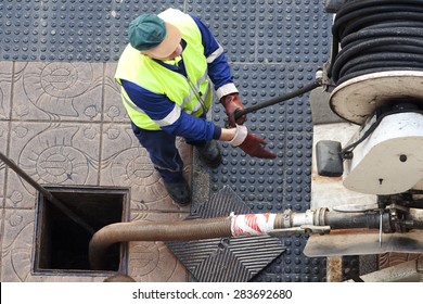 utility service company workers moves the manhole cover to cleaning the sewer line for clogs aerial view