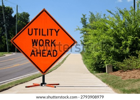 Utility work ahead warning sign beside roadway infrastructure project