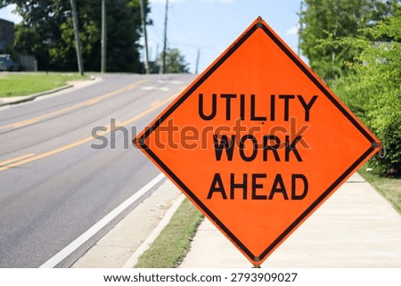 Utility work ahead warning sign beside roadway infrastructure project