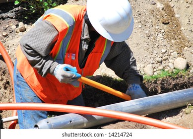 Utility Worker Repairing A Broken Water Pipe.